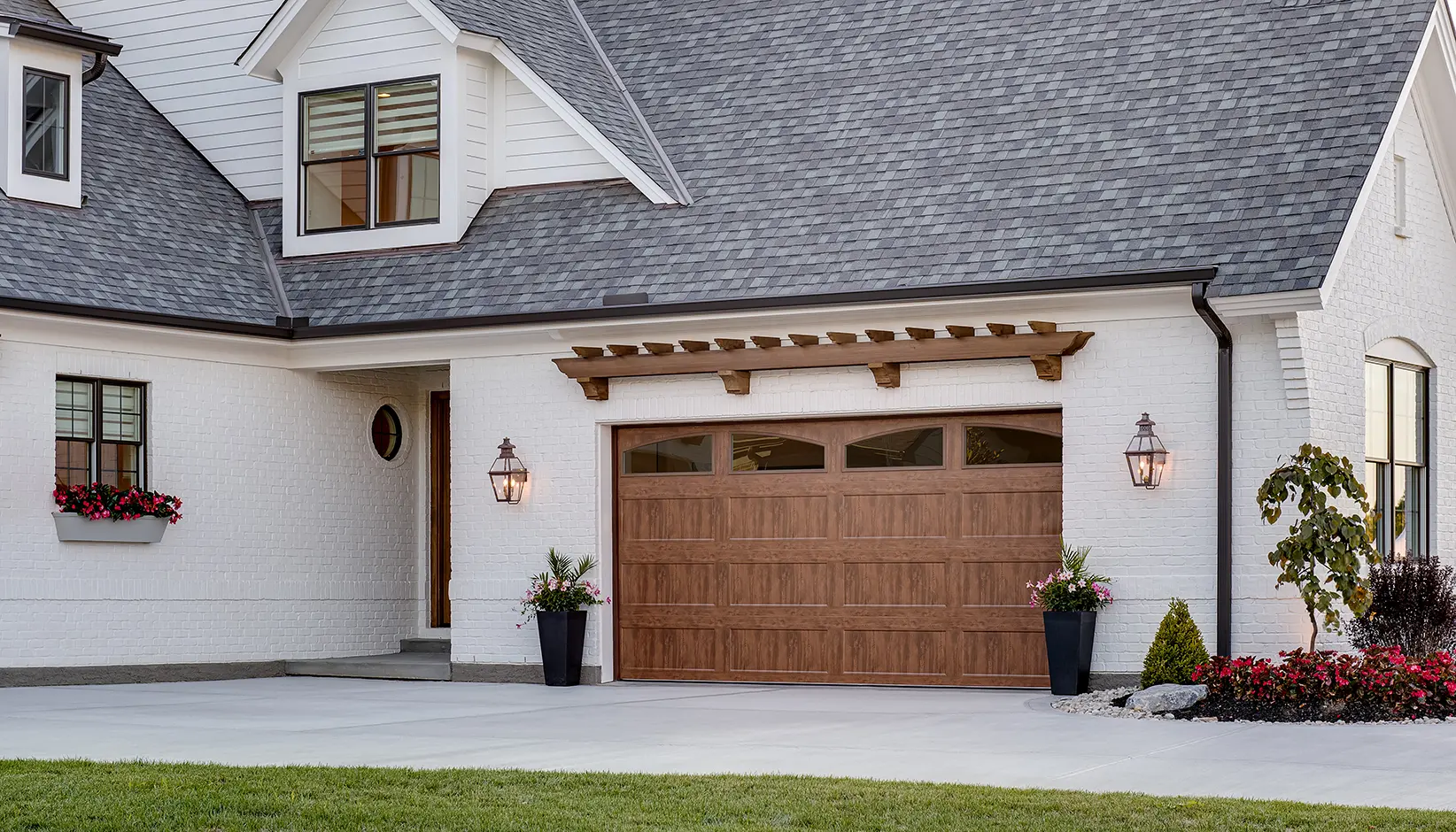 Bridgeport™ Steel garage door with extended recessed panels and ARCH1 Plain windows in Ultra-Grain® Dark finish